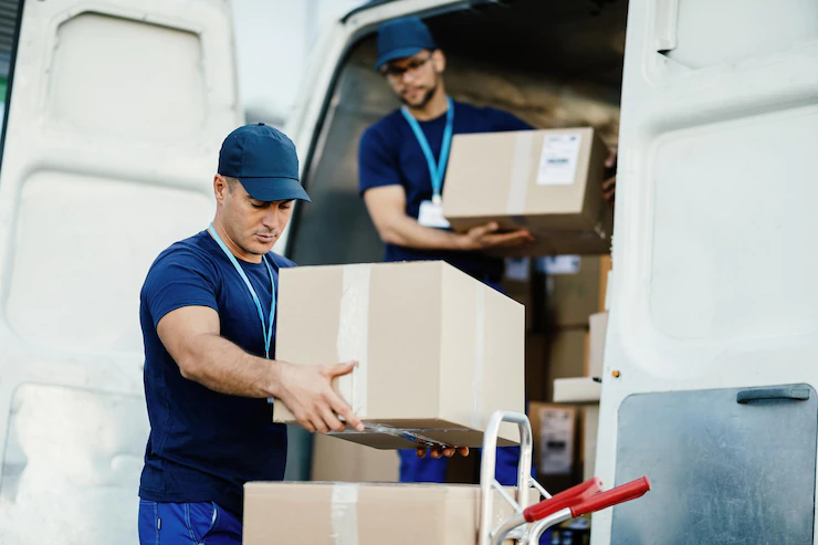 two movers unloading Cargo boxes from cargo van